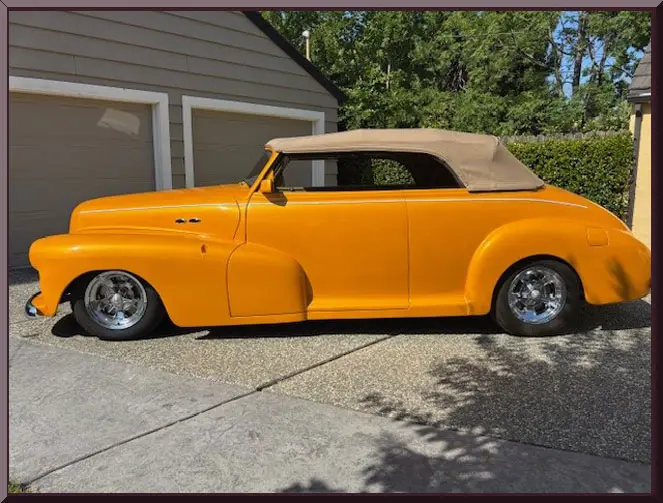 Bright orange retro car in driveway