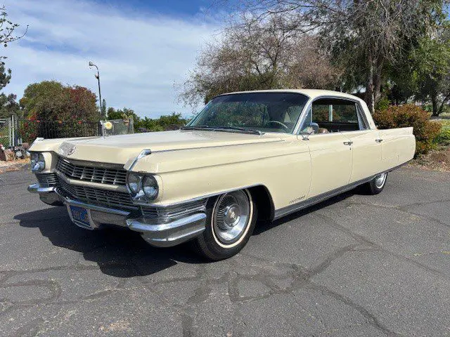 Cream vintage Cadillac four-door parked outdoors