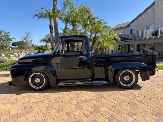 Black vintage pickup truck on brick driveway