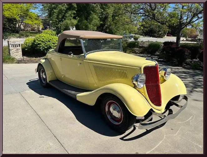 Yellow vintage convertible car parked on driveway