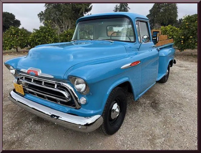 Classic blue vintage pickup truck parked outdoors.