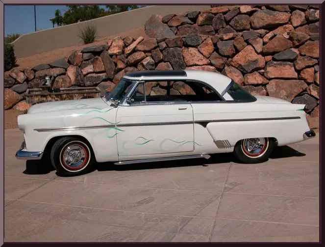 White 1950s lowrider coupe with green flames