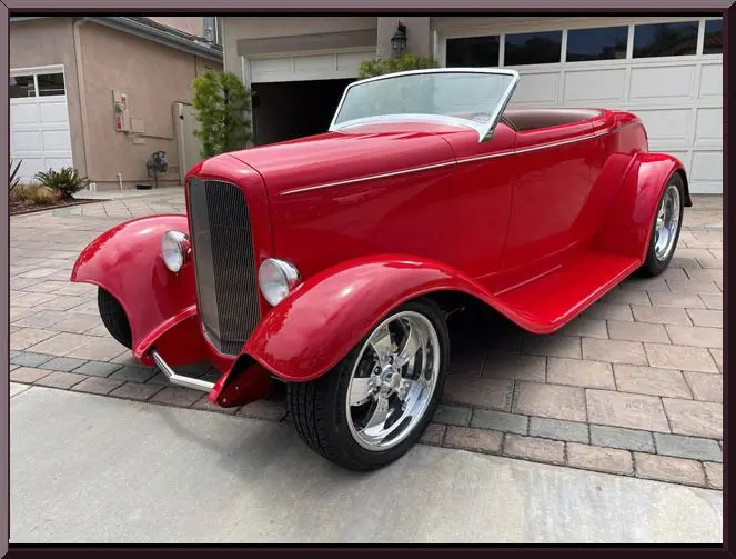 Stylish red antique car in front of garage
