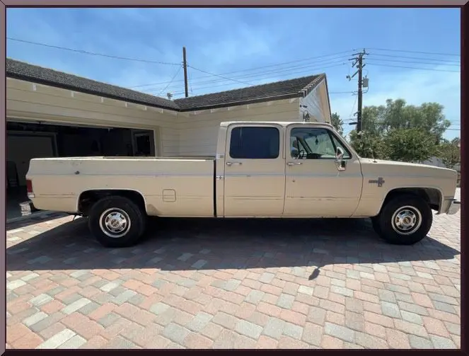 Beige truck with extended cab in sunlight.