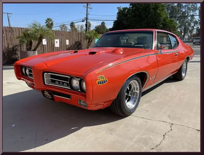Retro GTO vehicle in sunny driveway