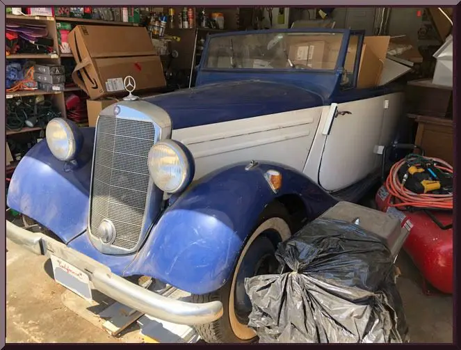 Antique automobile surrounded by boxes and items