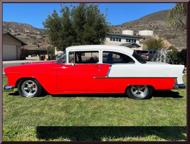 Red-and-white classic car parked on grass