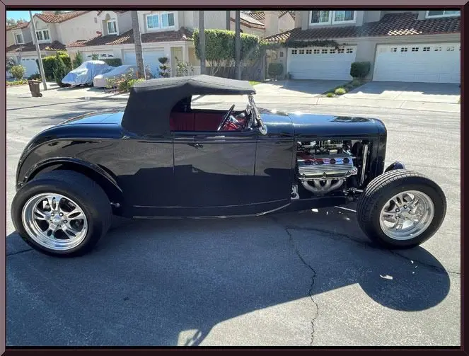 Classic black hot rod parked on street.