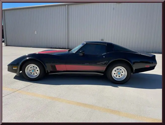 Black sports car parked outside warehouse
