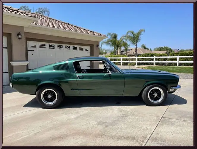 Vintage green vehicle with white garage