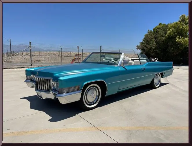 Turquoise vintage Cadillac convertible parked outdoors