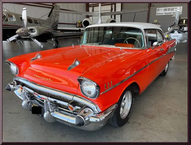 Vintage car parked near planes