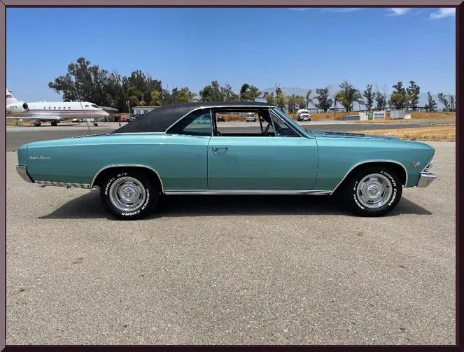 Vintage teal car parked on tarmac