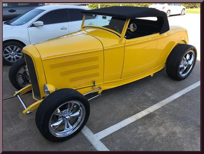 Classic yellow hot rod parked outside