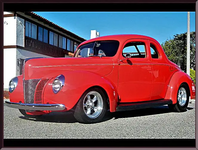 Glossy red vintage coupe with chrome wheels