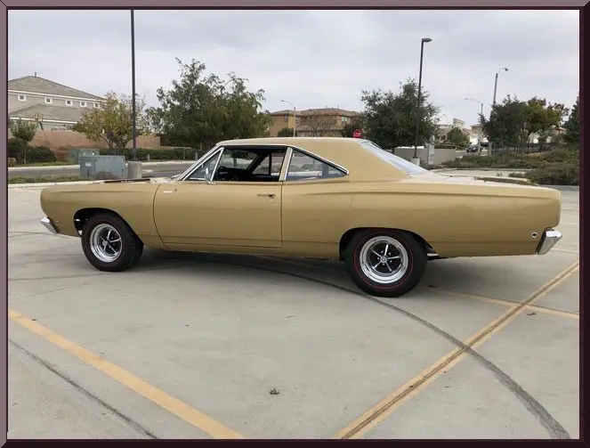 Gold vintage muscle car parked in lot