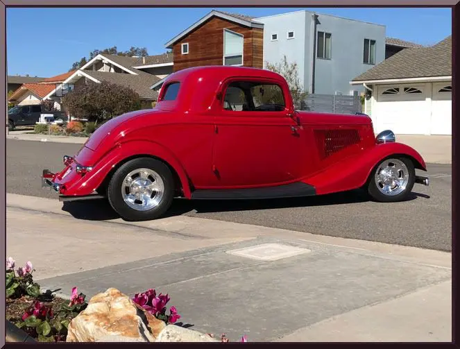 Red vintage hot rod coupe parked in neighborhood