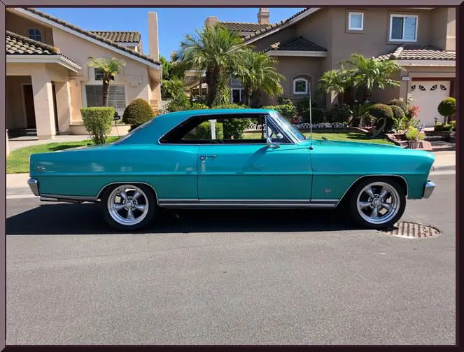 Vintage teal coupe in suburban neighborhood