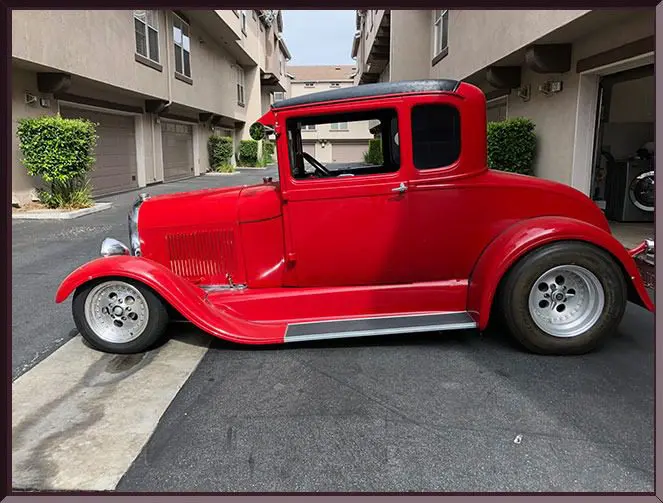 Red vintage car parked in residential area