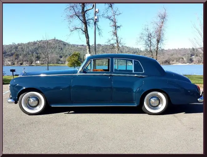 Classic blue car by a lakeside view