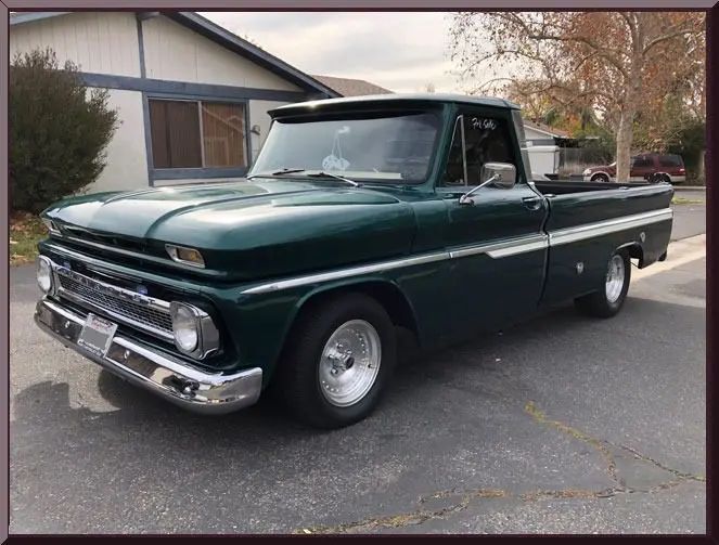 Classic green pickup truck parked on street.