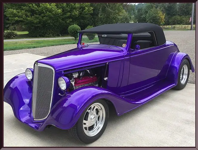 Shiny purple antique car with black roof