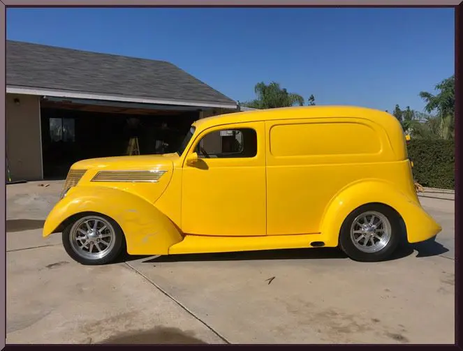 Yellow vintage car parked outside garage