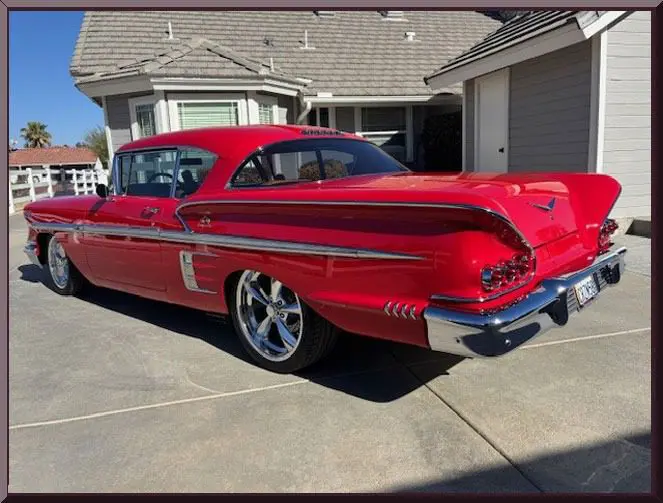 Classic red vintage car parked outside house