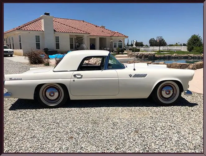 Classic white car parked by house