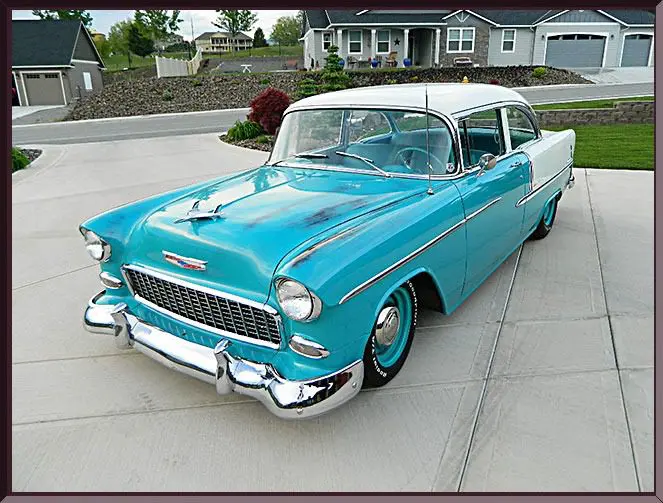 Classic turquoise car parked in driveway