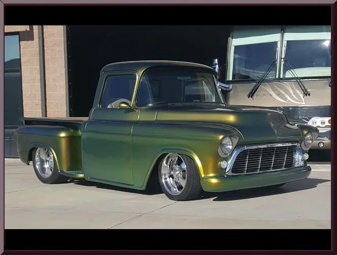 Retro green truck in front of garage