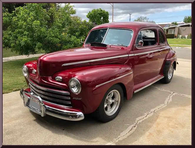 Classic maroon vintage coupe parked on driveway