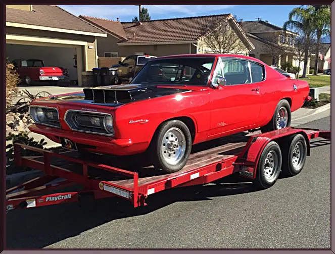 Red classic car on trailer