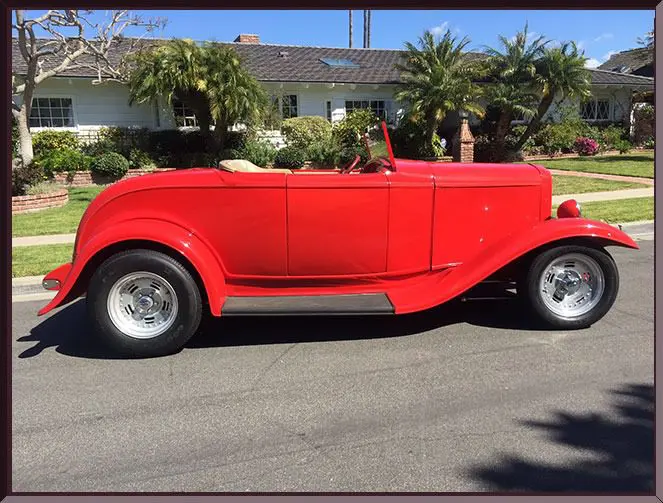 Retro red roadster outside suburban home