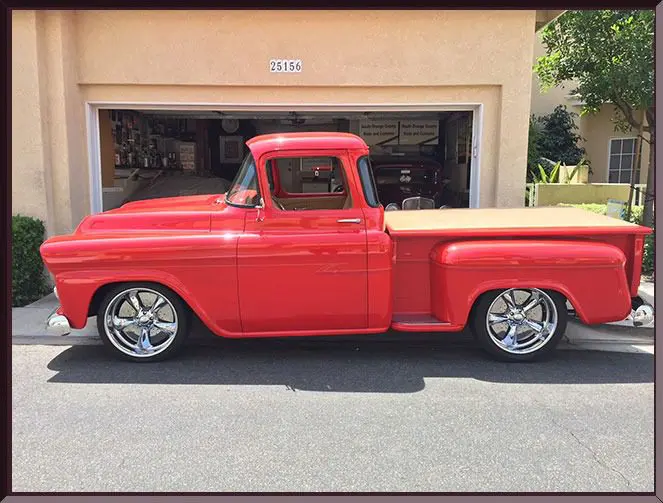 Classic red truck with shiny chrome wheels.