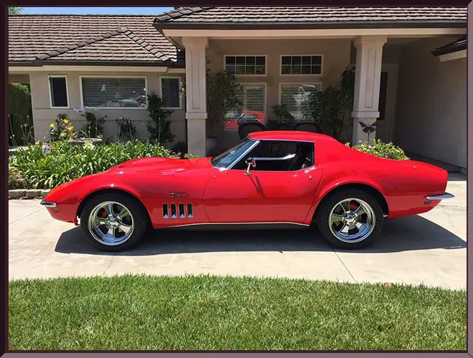Sleek red vehicle in front of home