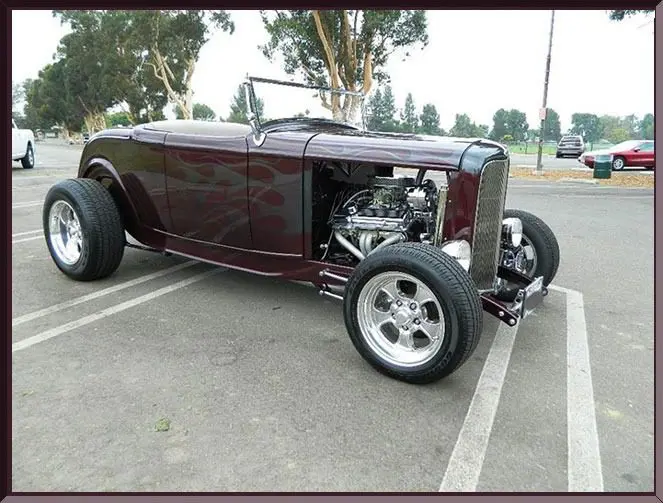 Maroon vintage hot rod roadster with exposed engine