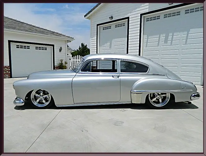 Shiny retro vehicle outside white garage