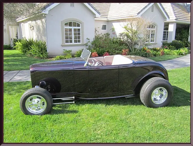 Classic black roadster parked on grass