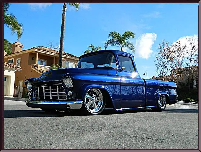 Vintage blue pickup truck on sunny street.