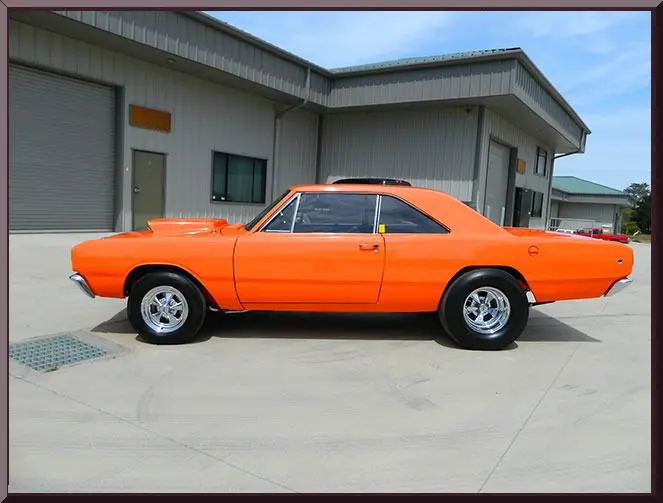 Orange classic car parked outside garage