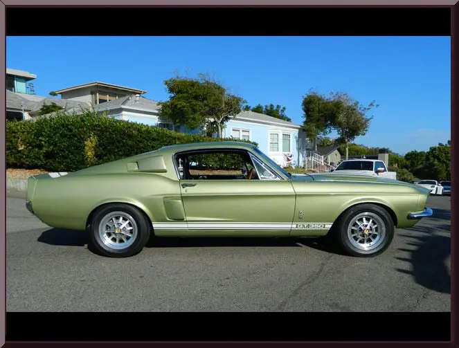 Retro green car under clear blue sky.