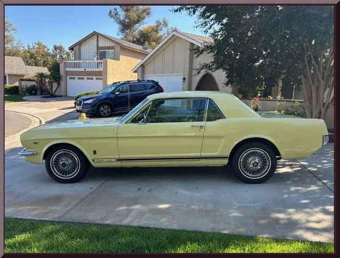 Classic car beside modern houses