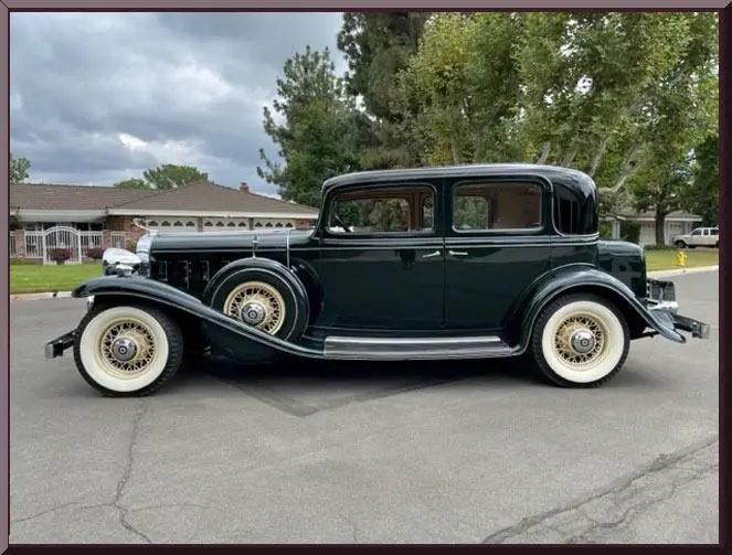 Vintage black classic car parked on street.