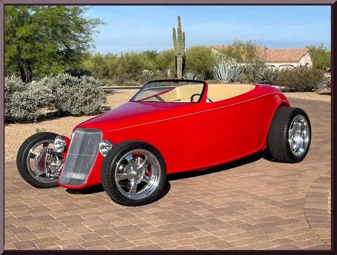 Red vintage car on brick driveway
